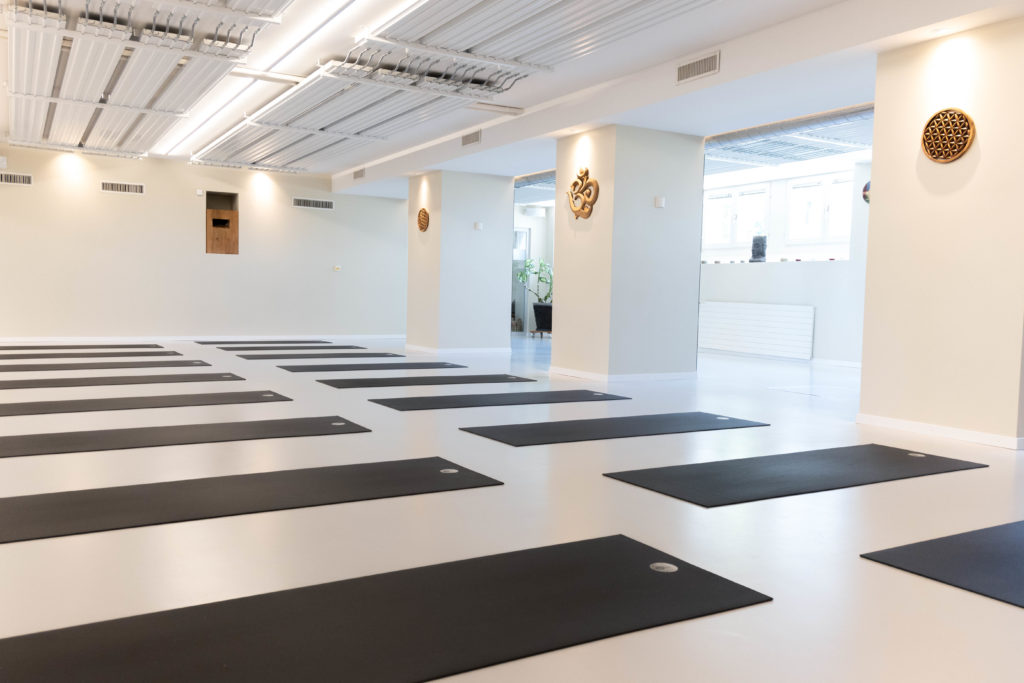 Group hot yoga class at Yoga Flame Lausanne. Studio de yoga moderne Yoga Flame à Lausanne. Yoga community Lausanne.